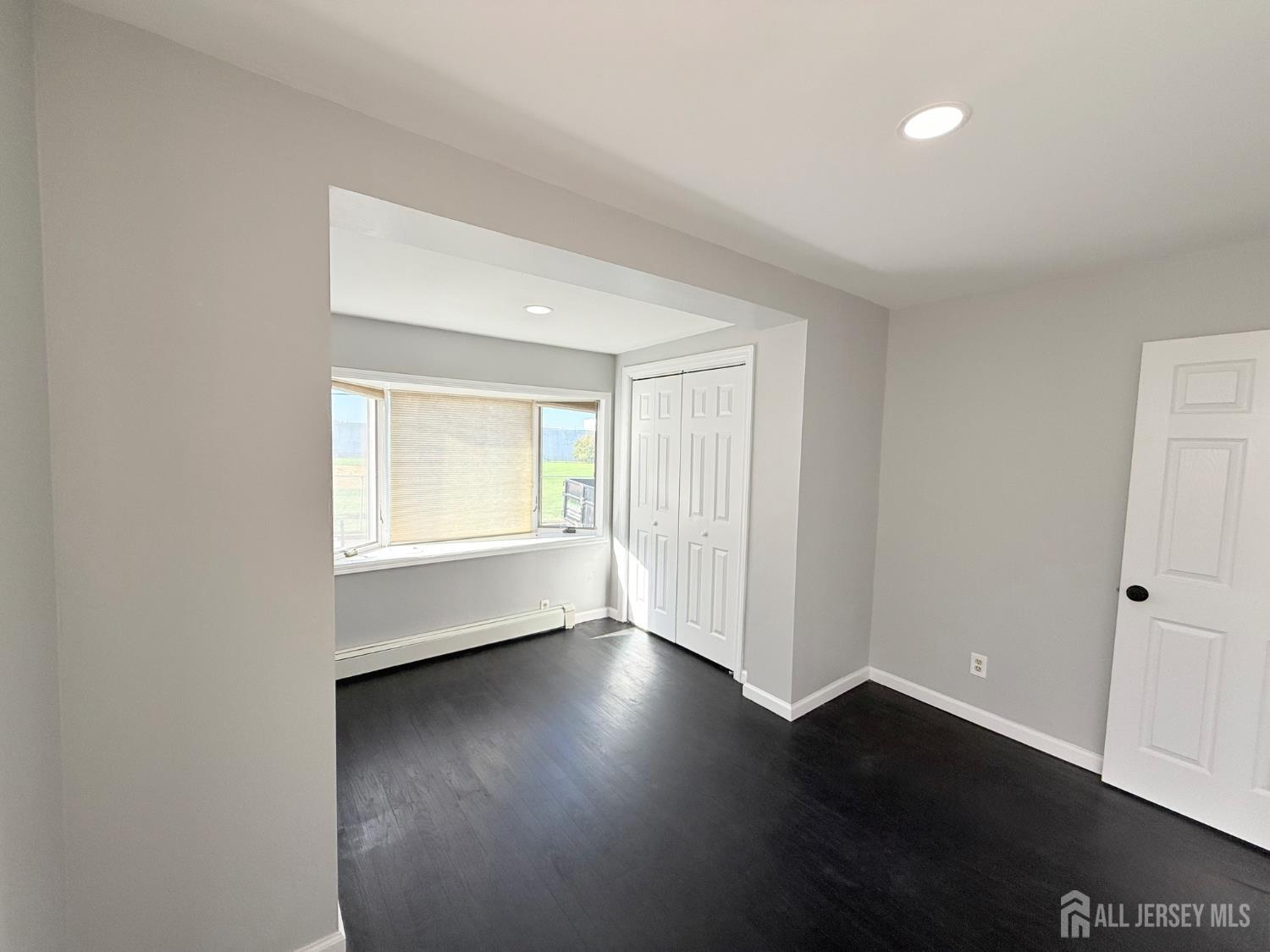46 Hayward Avenue, Unit 1 Carteret, NJ 07008 - Photo 3 of 9 an empty room with wooden floor and windows