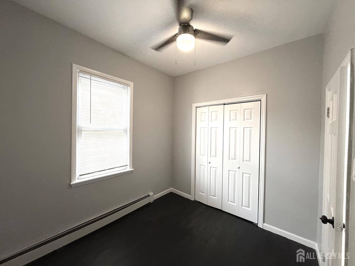 46 Hayward Avenue, Unit 1 Carteret, NJ 07008 - Photo 5 of 9 a view of an empty room with a window and wooden floor