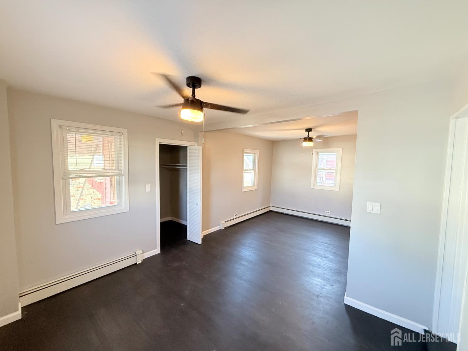 46 Hayward Avenue, Unit 1 Carteret, NJ 07008 - Photo 7 of 9 an empty room with wooden floor and windows