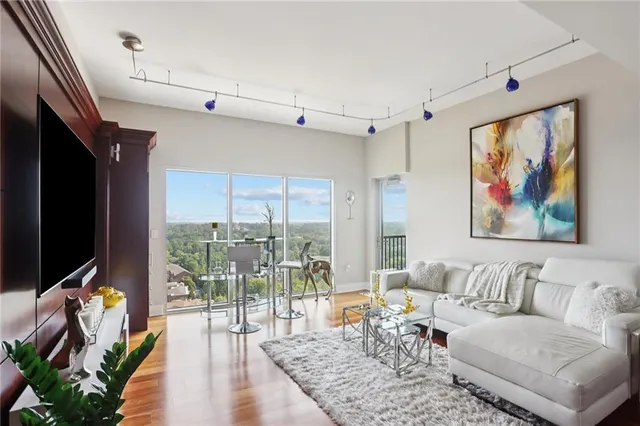 a living room with furniture flat screen tv and a large window