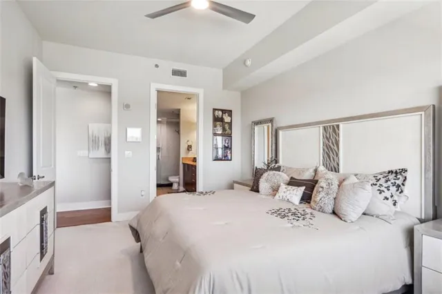a bedroom with a large bed and a chandelier