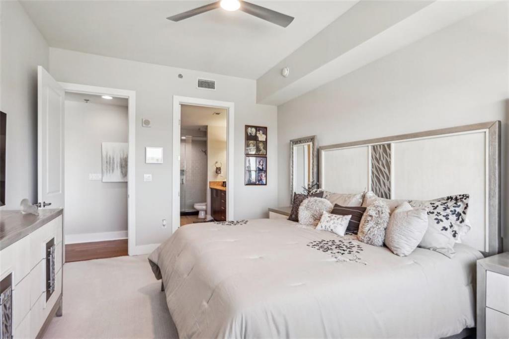 4561 Olde Perimeter Way, Unit 2609 Atlanta, GA 30346 - Photo 13 of 45 a bedroom with a large bed and a chandelier