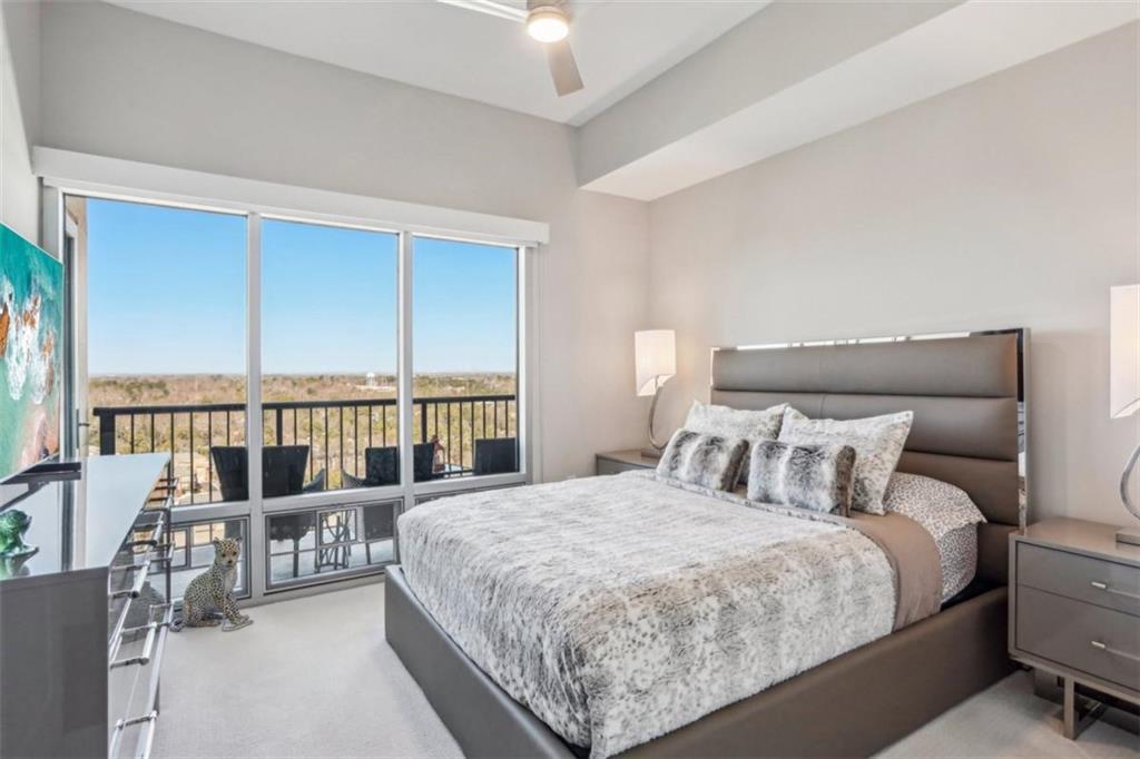 4561 Olde Perimeter Way, Unit 2609 Atlanta, GA 30346 - Photo 16 of 45 a large bed sitting in a bedroom next to a balcony next to a large window