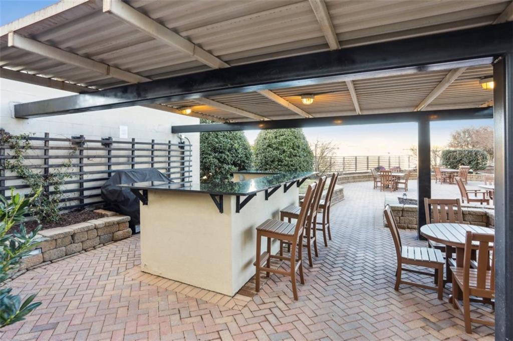 4561 Olde Perimeter Way, Unit 2609 Atlanta, GA 30346 - Photo 25 of 45 a view of a patio with table and chairs with wooden floor and fence