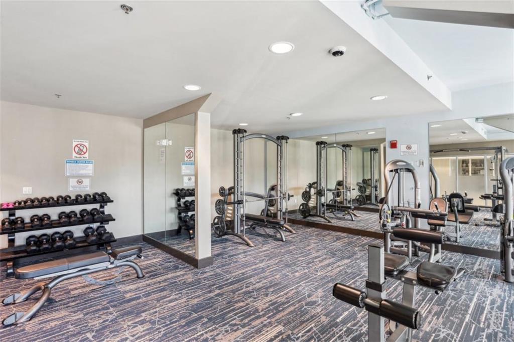 4561 Olde Perimeter Way, Unit 2609 Atlanta, GA 30346 - Photo 34 of 45 a living room with furniture a wooden floor and white walls