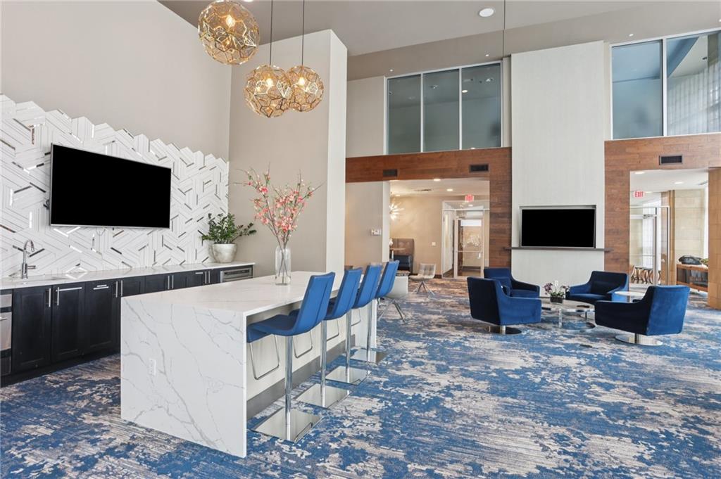 4561 Olde Perimeter Way, Unit 2609 Atlanta, GA 30346 - Photo 37 of 45 a living room with furniture a flat screen tv and kitchen view