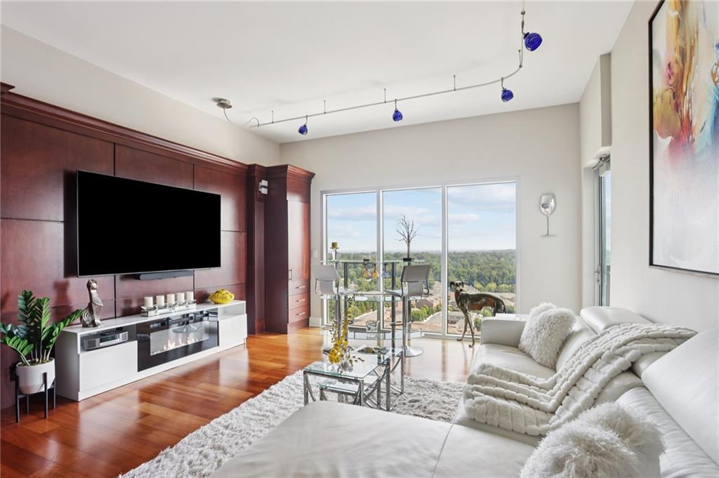 4561 Olde Perimeter Way, Unit 2609 Atlanta, GA 30346 - Photo 5 of 45 a living room with furniture and a flat screen tv