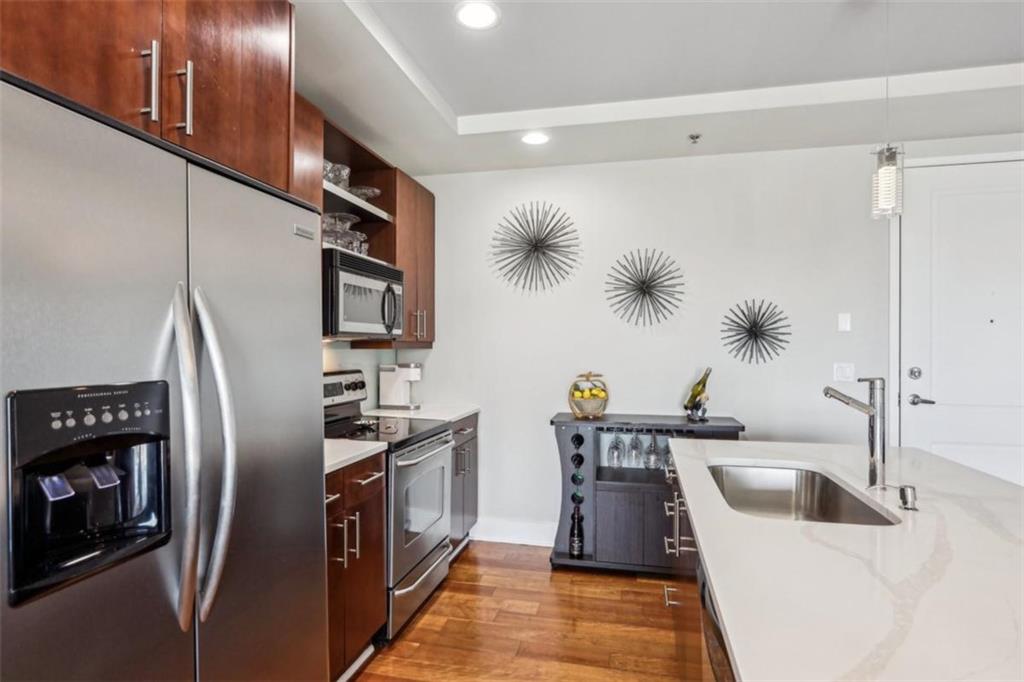 4561 Olde Perimeter Way, Unit 2609 Atlanta, GA 30346 - Photo 10 of 45 a kitchen with stainless steel appliances a refrigerator a sink a stove and a refrigerator