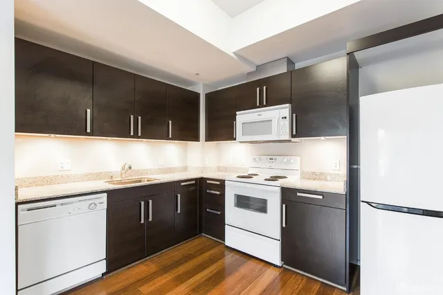 a kitchen with a sink a refrigerator and cabinets