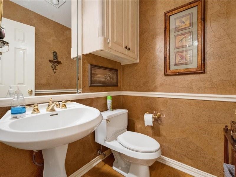 1704 South Bowen Road Pantego, TX 76013 - Photo 18 of 26 a bathroom with a toilet sink and mirror