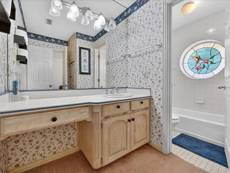 1704 South Bowen Road Pantego, TX 76013 - Photo 21 of 26 a bathroom with a sink double vanity and a bathtub