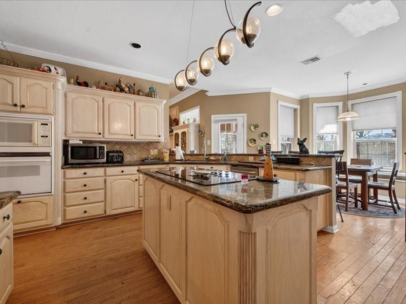 1704 South Bowen Road Pantego, TX 76013 - Photo 9 of 26 a kitchen with granite countertop a sink a counter top space appliances and cabinets