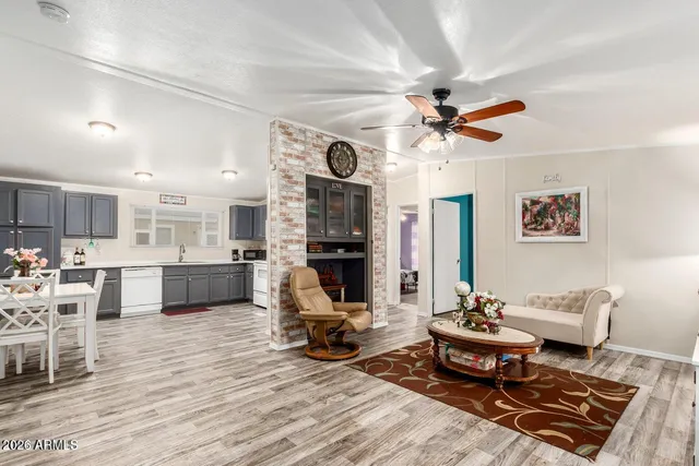 a living room with furniture a table and kitchen view