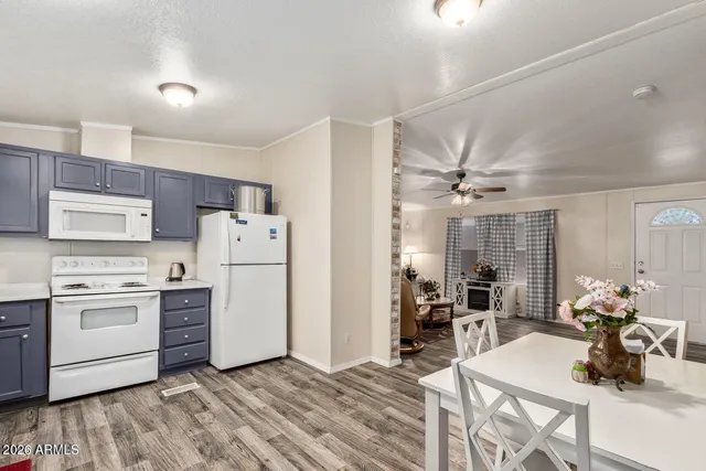 a kitchen with stainless steel appliances a stove a refrigerator cabinets dining table and chairs