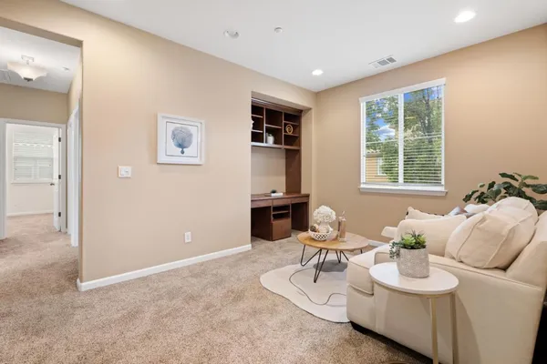 a living room with furniture a window and a flat screen tv