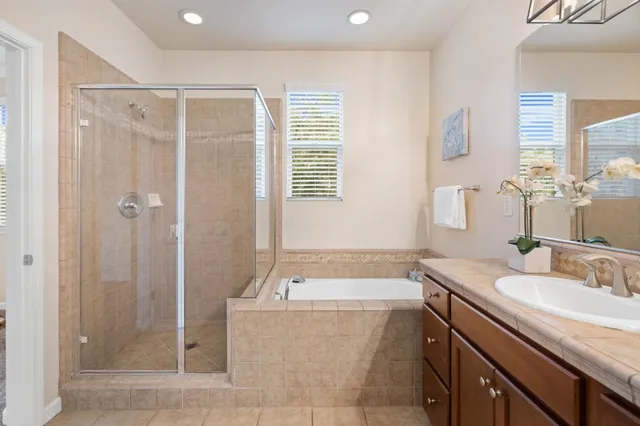 a bathroom with a granite countertop tub sink and shower