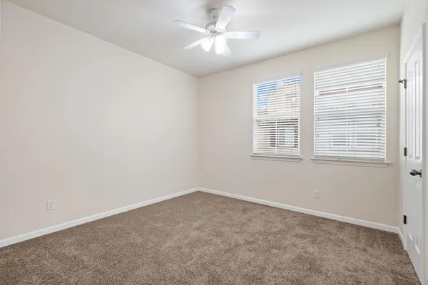 an empty room with a window and a fan