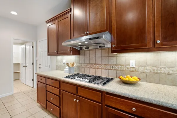 a kitchen with stainless steel appliances granite countertop a sink a stove and cabinets