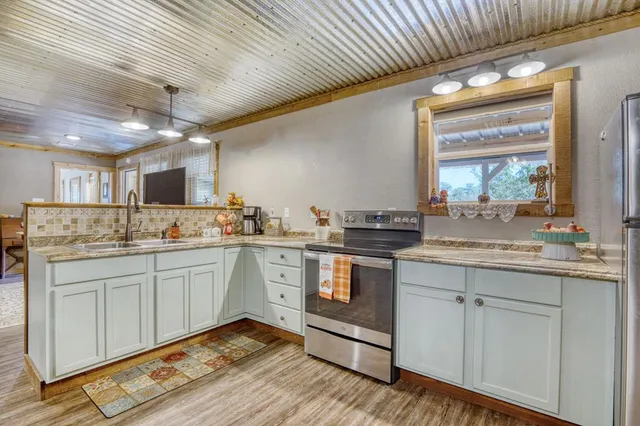 a kitchen with sink stove and cabinets