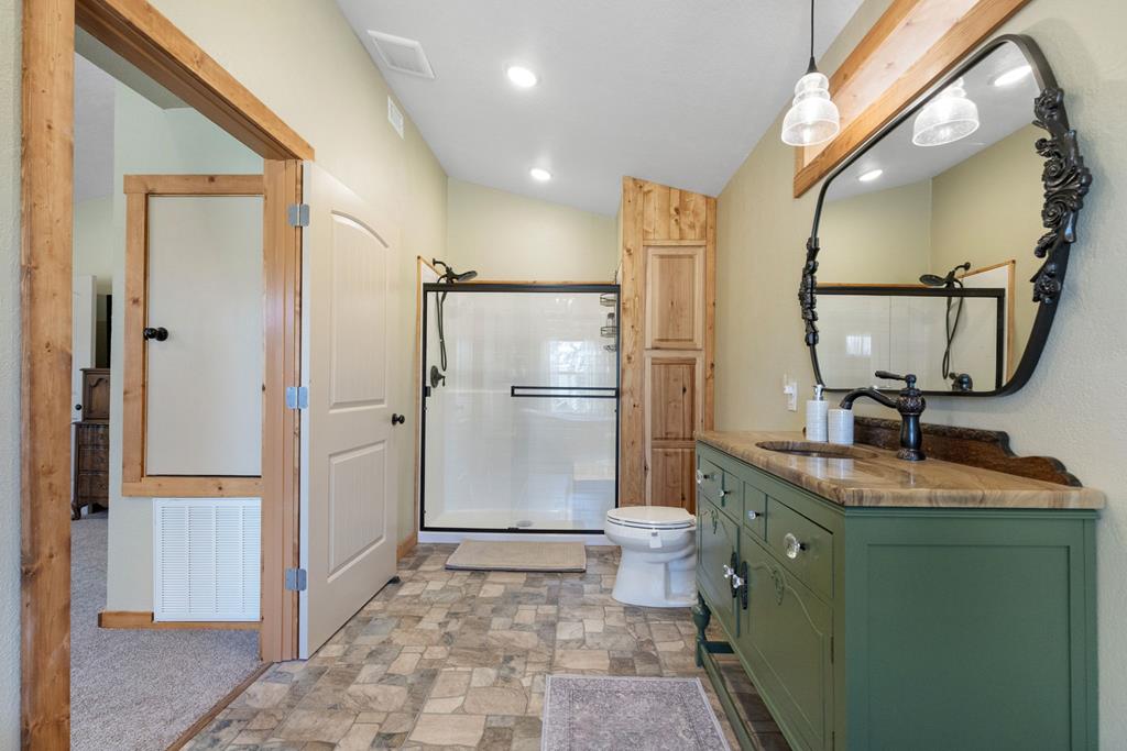 25525 Ranch Road 2323 Llano, TX 78643 - Photo 23 of 40 a bathroom with a granite countertop sink a mirror and shower