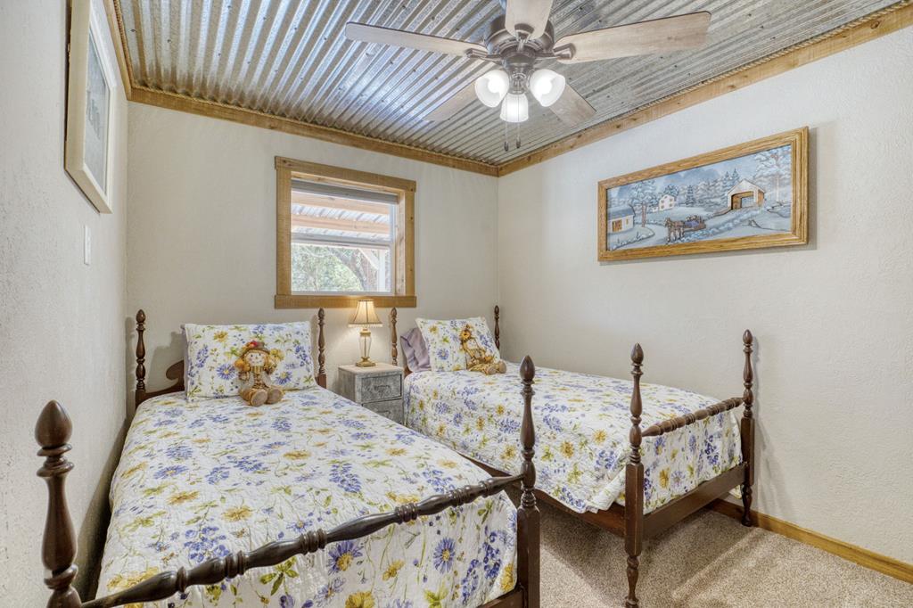 25525 Ranch Road 2323 Llano, TX 78643 - Photo 24 of 40 a bedroom with furniture and a chandelier