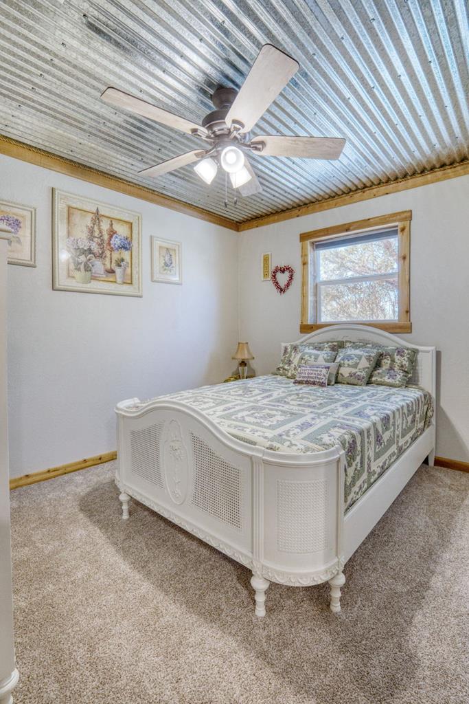 25525 Ranch Road 2323 Llano, TX 78643 - Photo 25 of 40 a bedroom with a bed and a chandelier