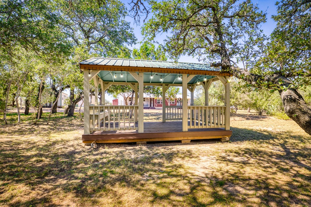 25525 Ranch Road 2323 Llano, TX 78643 - Photo 8 of 40 a view of a patio with table and chairs under an umbrella