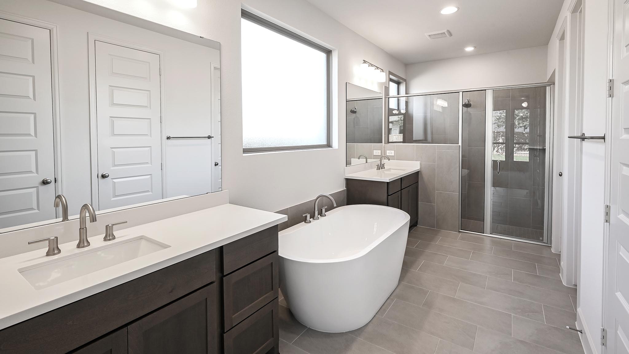 523 Prickly Poppy Loop Kyle, TX 78640 - Photo 20 of 40 a bathroom with a double vanity sink mirror and bathtub