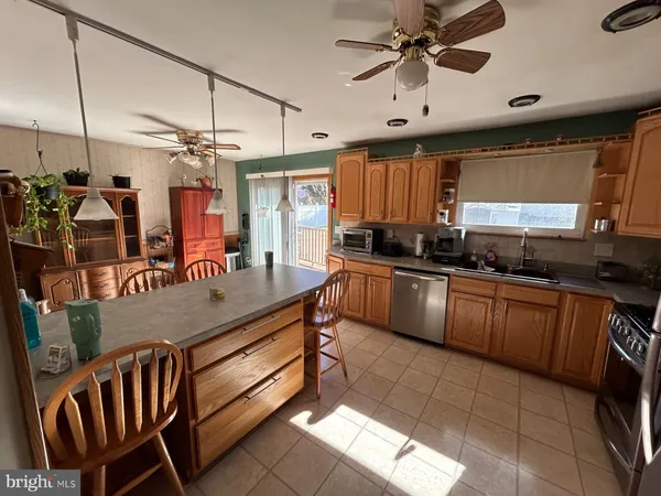 a kitchen with kitchen island granite countertop a sink cabinets and window