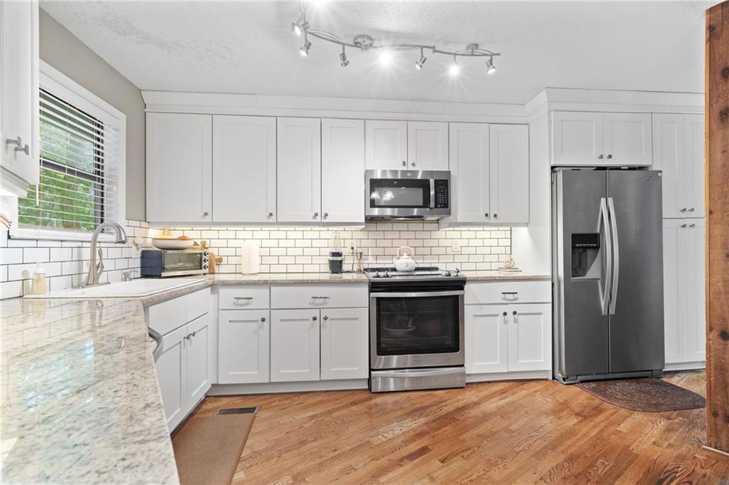 816 Mulligan Way Jasper, GA 30143 - Photo 13 of 36 a kitchen with stainless steel appliances granite countertop a stove a sink dishwasher a refrigerator and a microwave oven