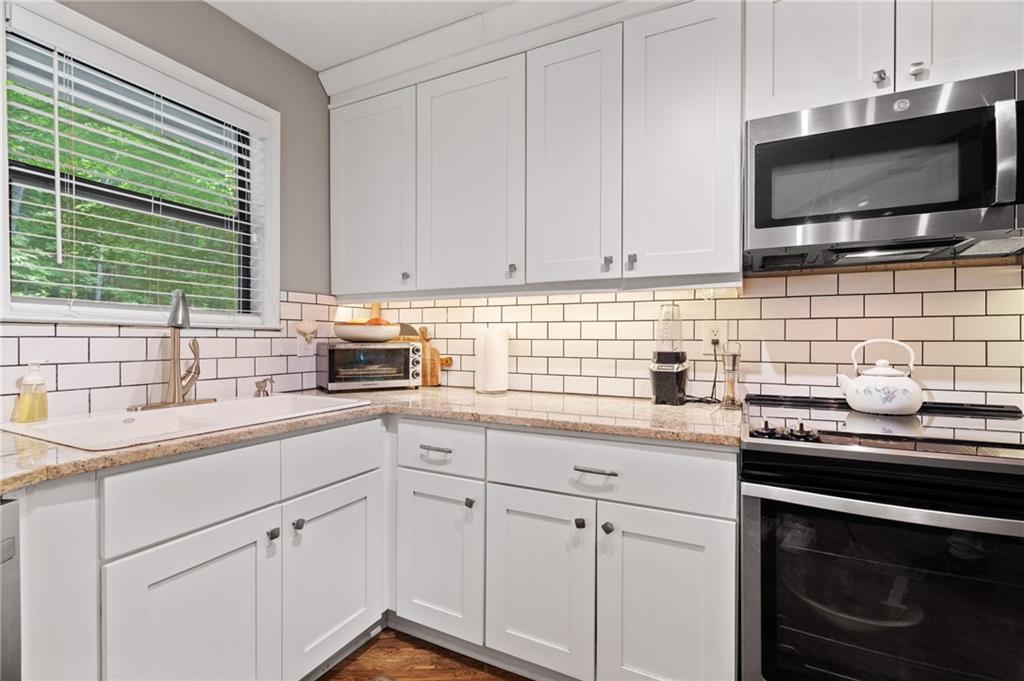 816 Mulligan Way Jasper, GA 30143 - Photo 14 of 36 a kitchen with a sink stove and cabinets