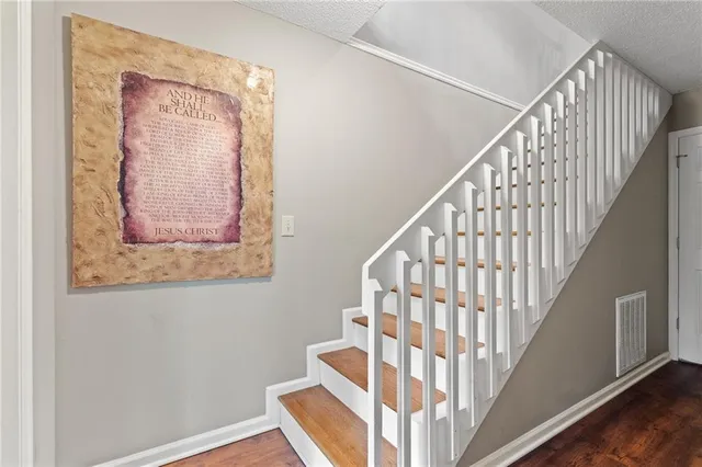 a view of staircase with wooden floor and white walls