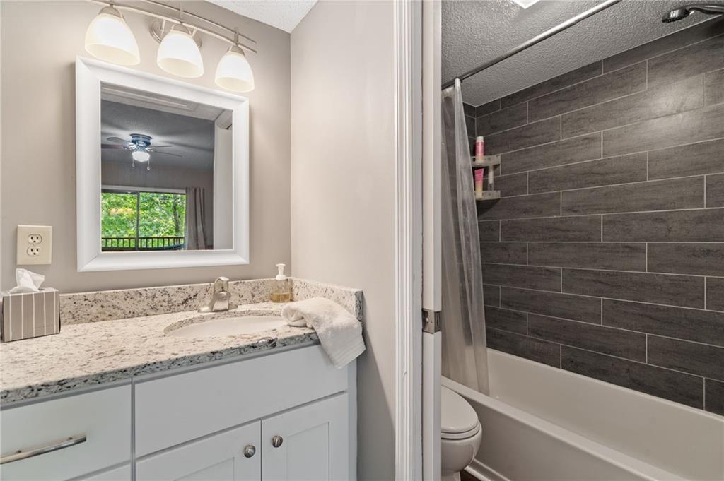 816 Mulligan Way Jasper, GA 30143 - Photo 25 of 36 a bathroom with a granite countertop sink toilet and shower