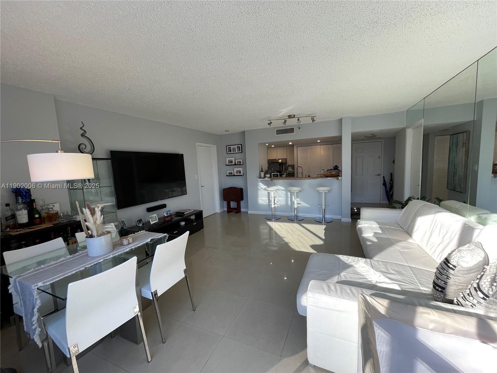 540 Brickell Key Drive, Unit 711 Miami, FL 33131 - Photo 12 of 37 a living room with furniture and a flat screen tv