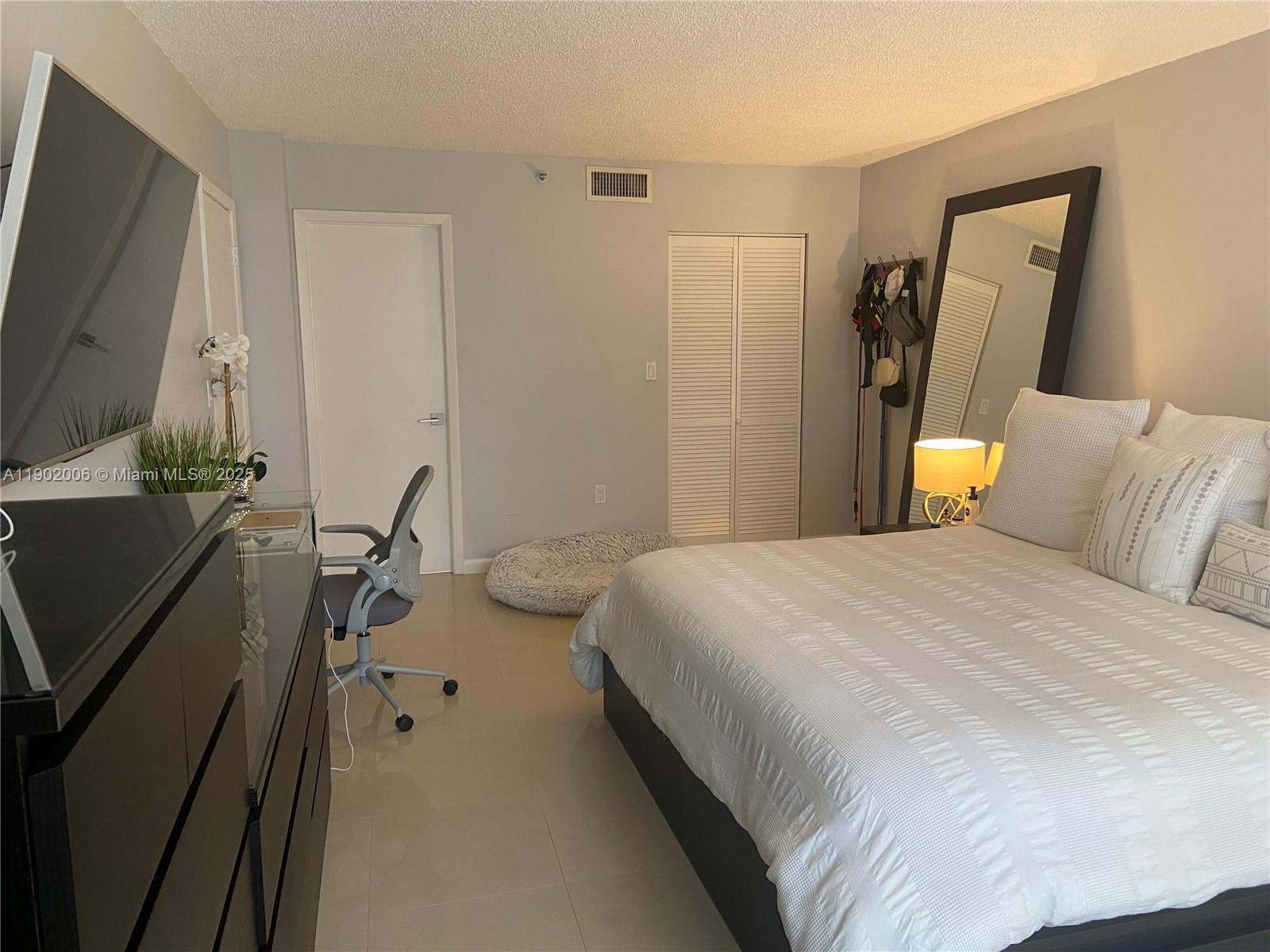 540 Brickell Key Drive, Unit 711 Miami, FL 33131 - Photo 16 of 37 a bedroom with a bed and a flat screen tv