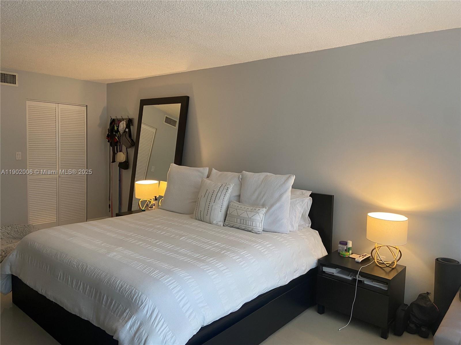 540 Brickell Key Drive, Unit 711 Miami, FL 33131 - Photo 17 of 37 a bedroom with a bed and wooden floor