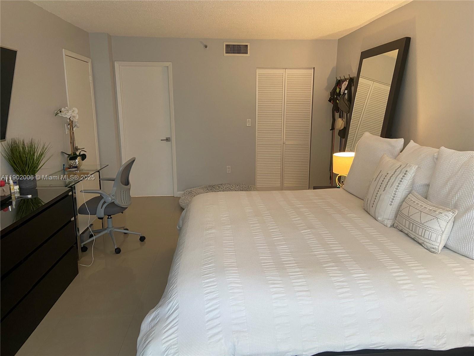 540 Brickell Key Drive, Unit 711 Miami, FL 33131 - Photo 18 of 37 a bed room with a bed window and mirror