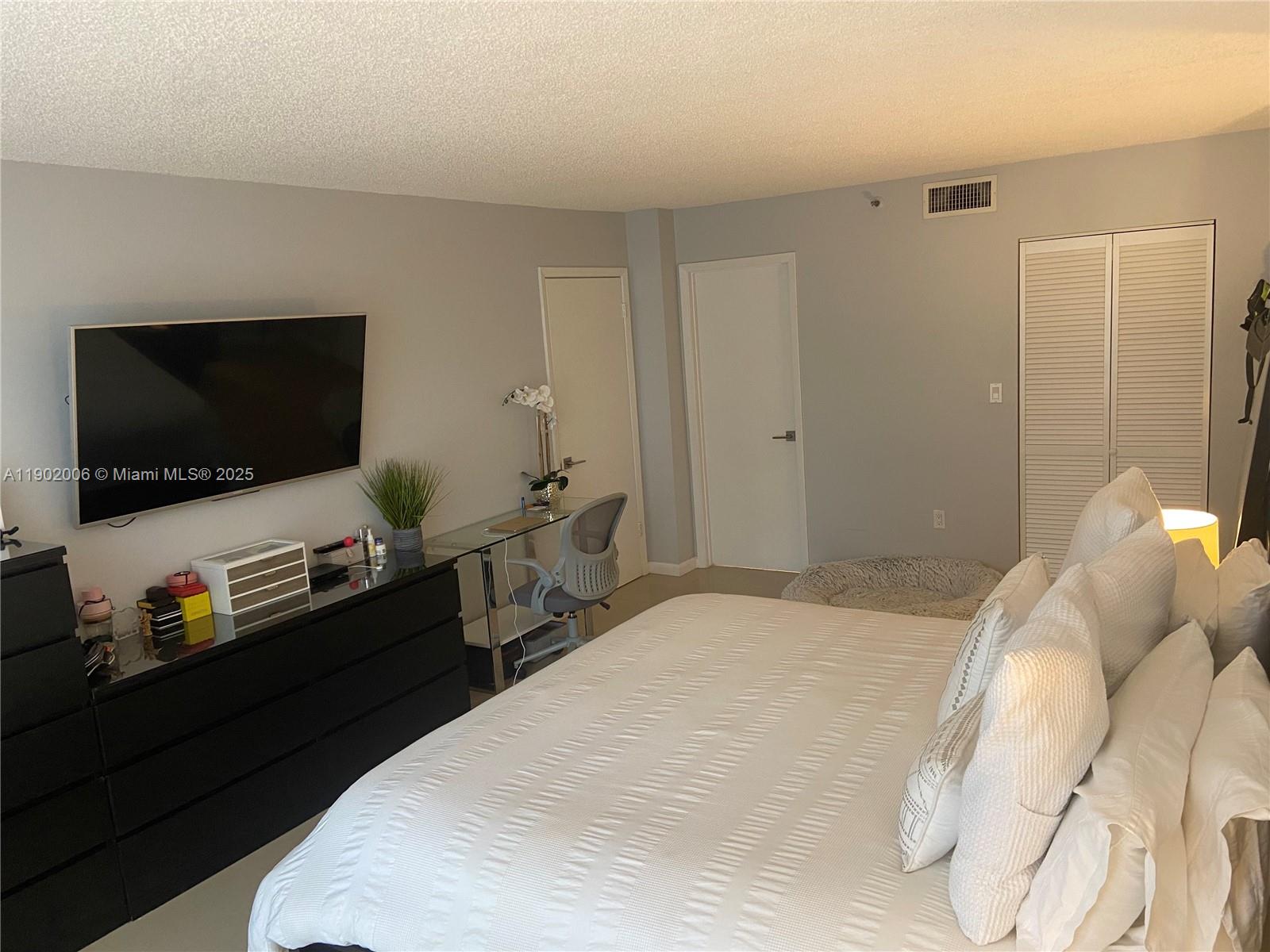 540 Brickell Key Drive, Unit 711 Miami, FL 33131 - Photo 19 of 37 a bedroom with a bed and a flat screen tv