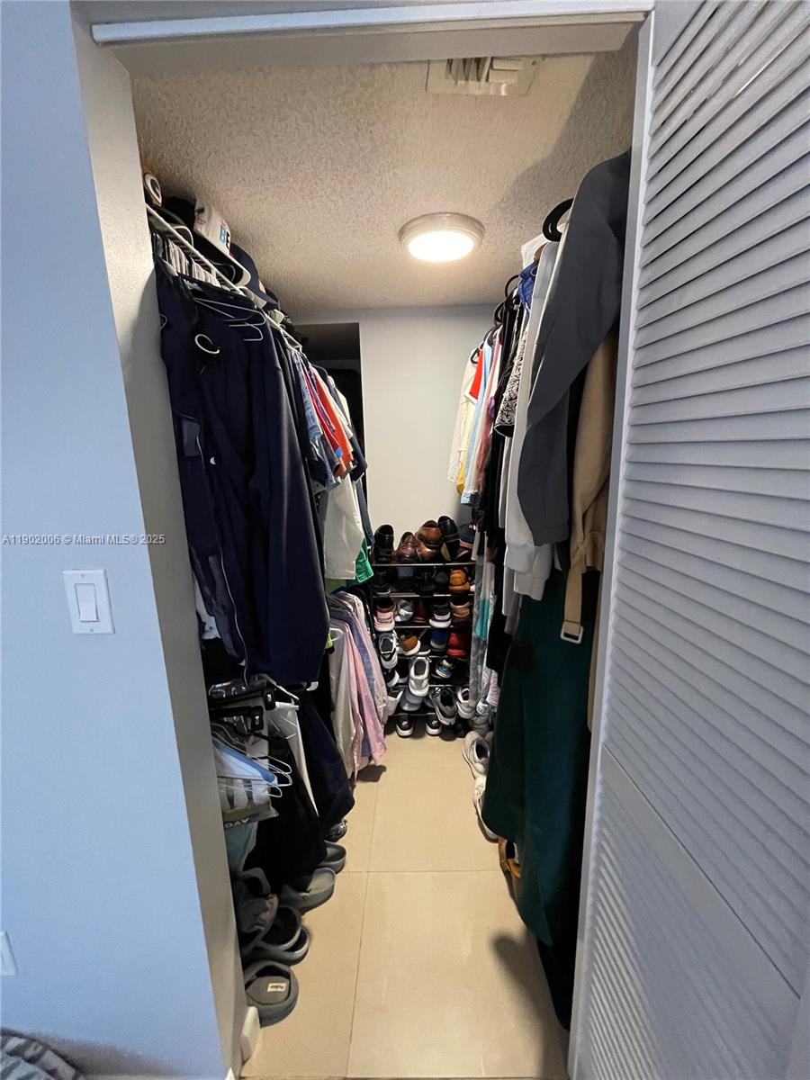 540 Brickell Key Drive, Unit 711 Miami, FL 33131 - Photo 20 of 37 a view of walk in closet with clothes
