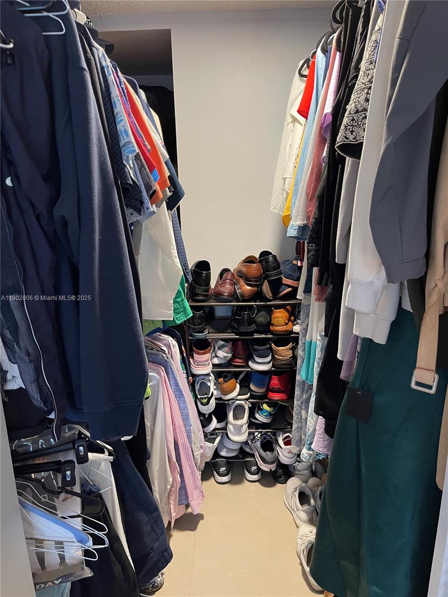 540 Brickell Key Drive, Unit 711 Miami, FL 33131 - Photo 21 of 37 a view of walk in closet with clothes and shoes