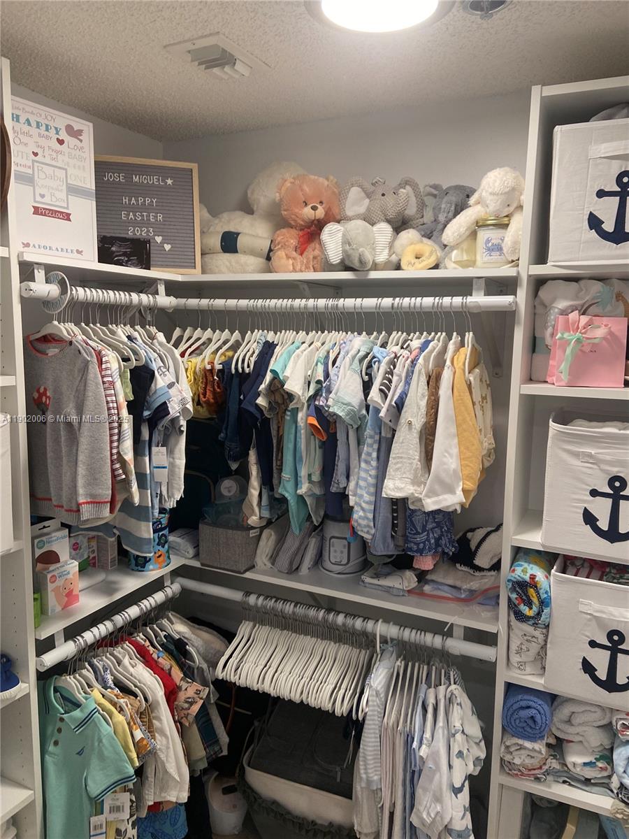 540 Brickell Key Drive, Unit 711 Miami, FL 33131 - Photo 26 of 37 a view of walk in closet with clothes and shoes