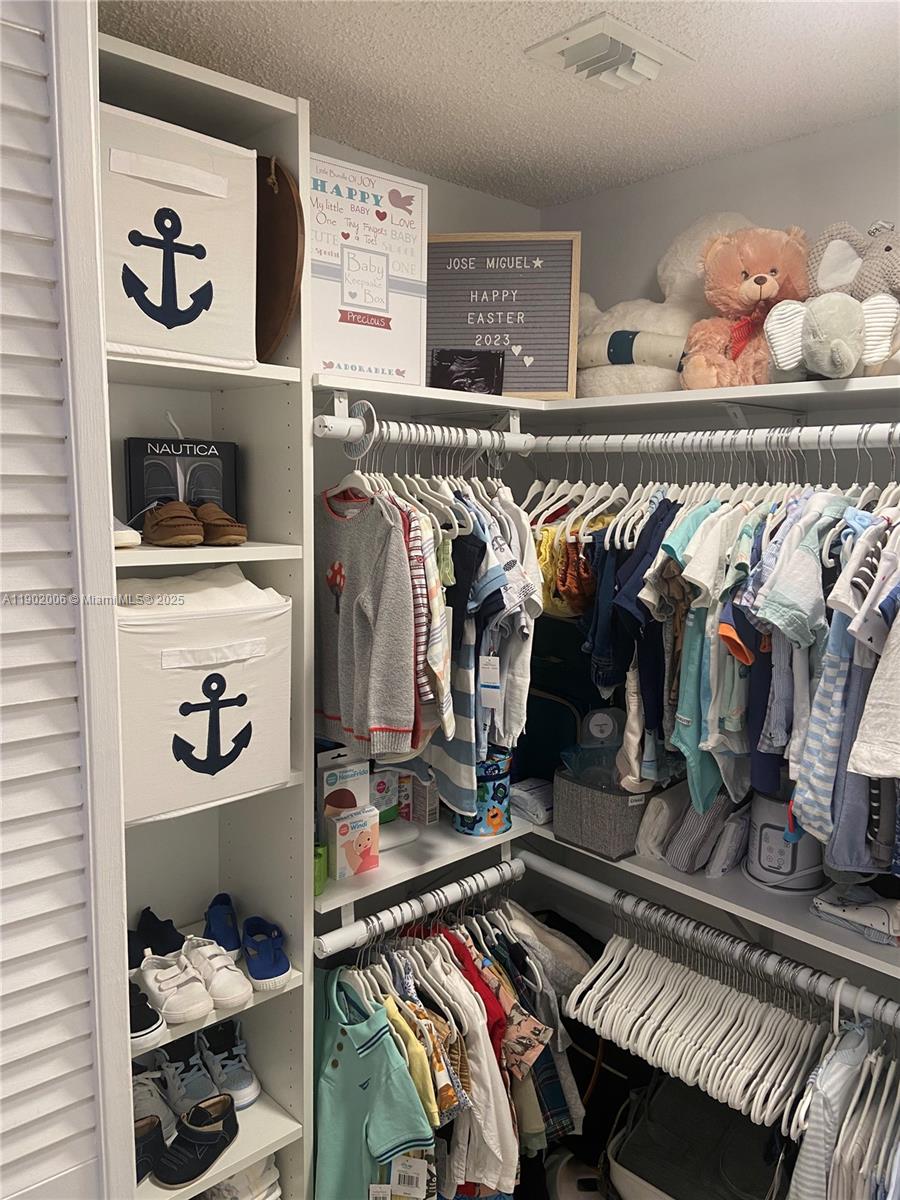 540 Brickell Key Drive, Unit 711 Miami, FL 33131 - Photo 27 of 37 a view of walk in closet with clothes and shoes
