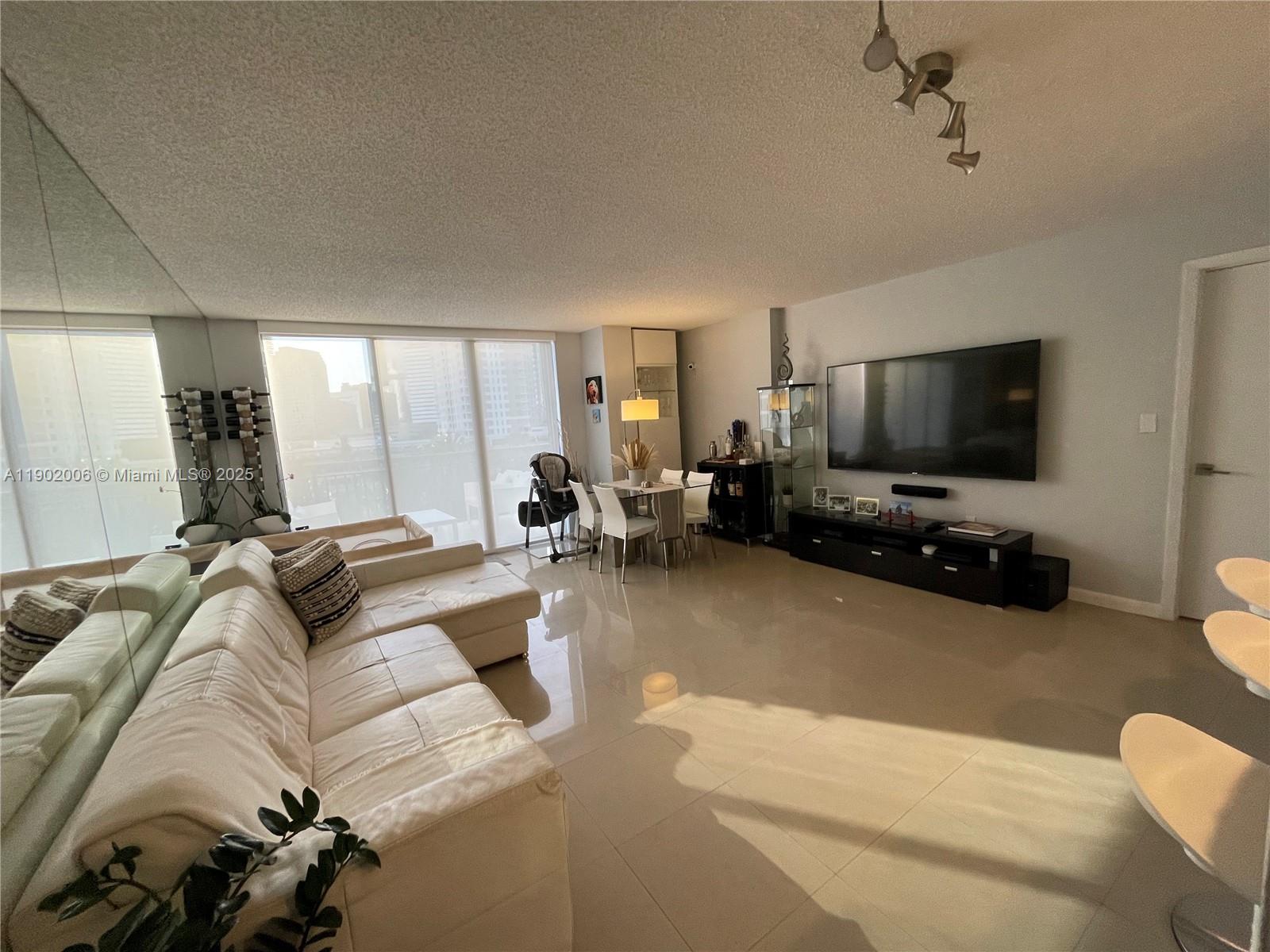 540 Brickell Key Drive, Unit 711 Miami, FL 33131 - Photo 9 of 37 a living room with furniture and a flat screen tv