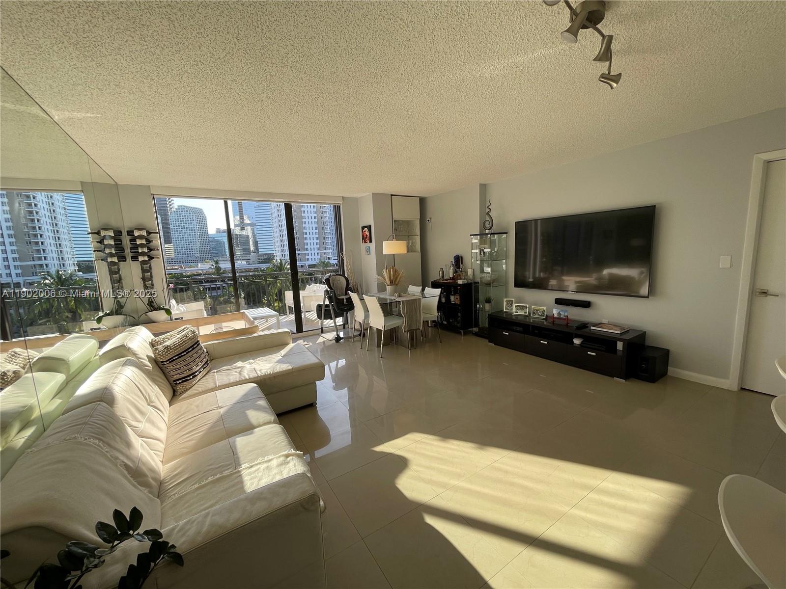 540 Brickell Key Drive, Unit 711 Miami, FL 33131 - Photo 10 of 37 a living room with furniture and a flat screen tv