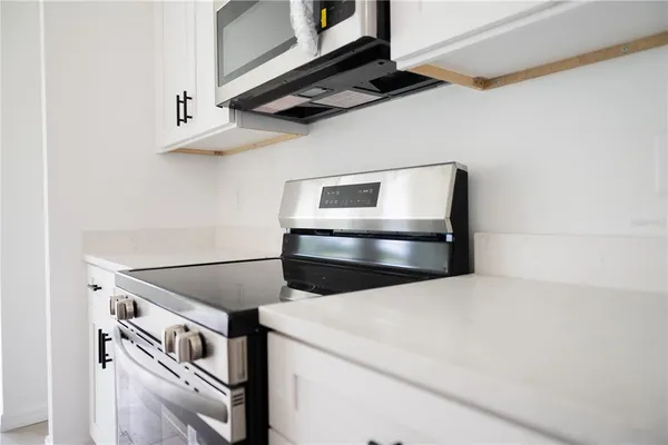 a view of a kitchen with a sink refrigerator and wooden floor
