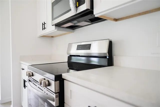 a view of a kitchen with a sink refrigerator and wooden floor