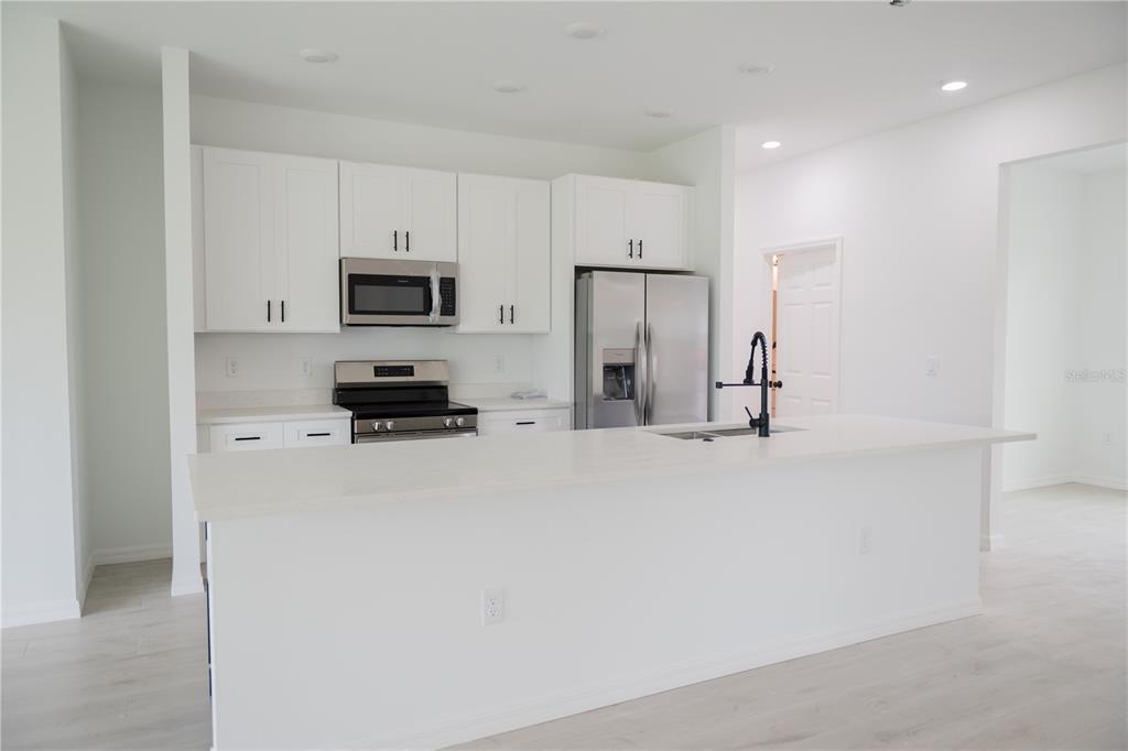 46 Master Drive Placida, FL 33946 - Photo 38 of 44 a kitchen with stainless steel appliances a refrigerator stove and white cabinets