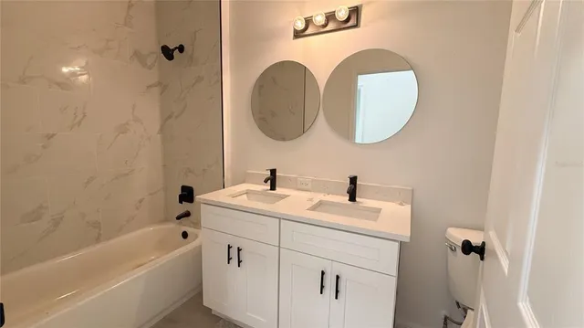 a kitchen with stainless steel appliances kitchen island a refrigerator sink and white cabinets