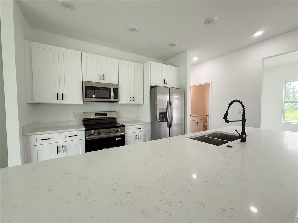 46 Master Drive Placida, FL 33946 - Photo 43 of 44 a kitchen with stainless steel appliances kitchen island a refrigerator sink and white cabinets