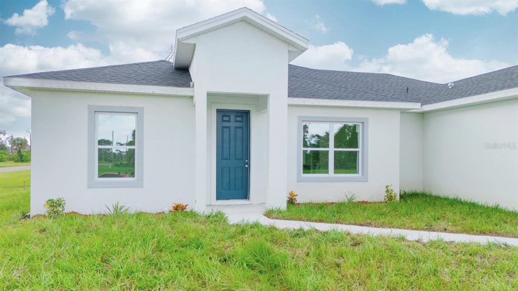 46 Master Drive Placida, FL 33946 - Photo 10 of 44 a front view of a house with a yard and garage